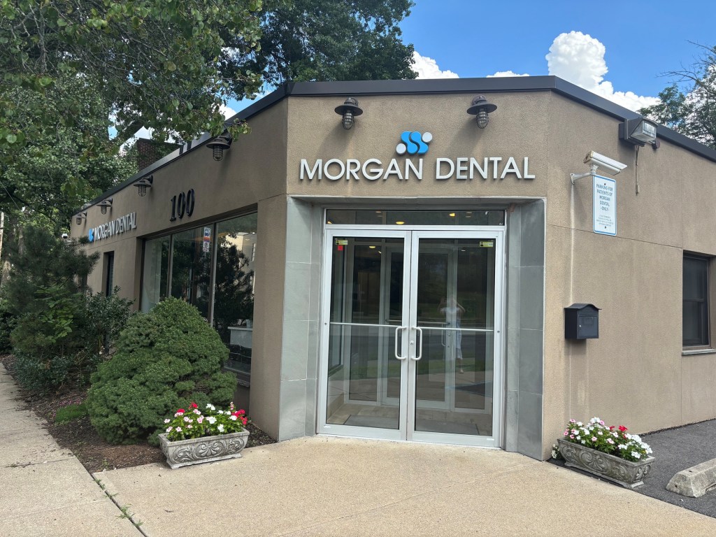 Exterior view of the Morgan Dental building entrance with glass doors and surrounding landscaping