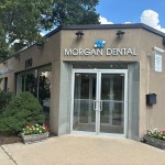 Exterior view of the Morgan Dental building entrance with glass doors and surrounding landscaping